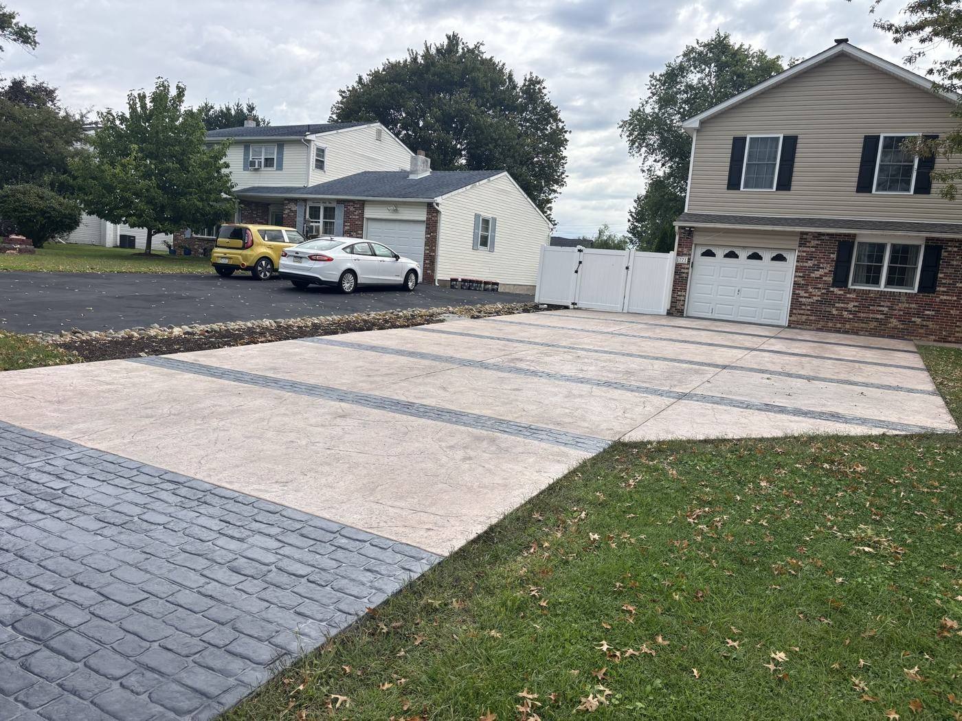 Driveway after: stamped concrete with charcoal cobblestone bands and apron