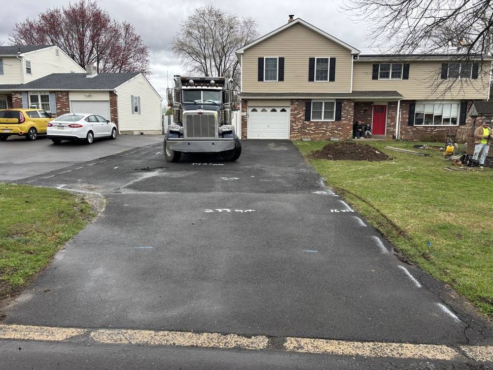 Driveway before: worn, patched asphalt