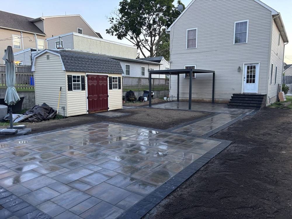 Large paver patio with charcoal border and walkway to the house