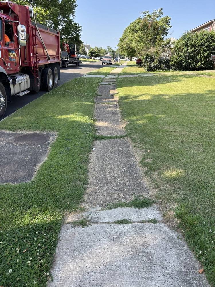 Cracked, sunken sidewalk before